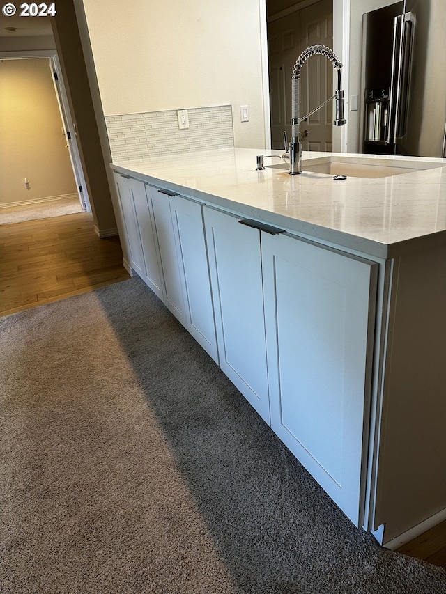 kitchen with light hardwood / wood-style flooring, high quality fridge, kitchen peninsula, and white cabinetry