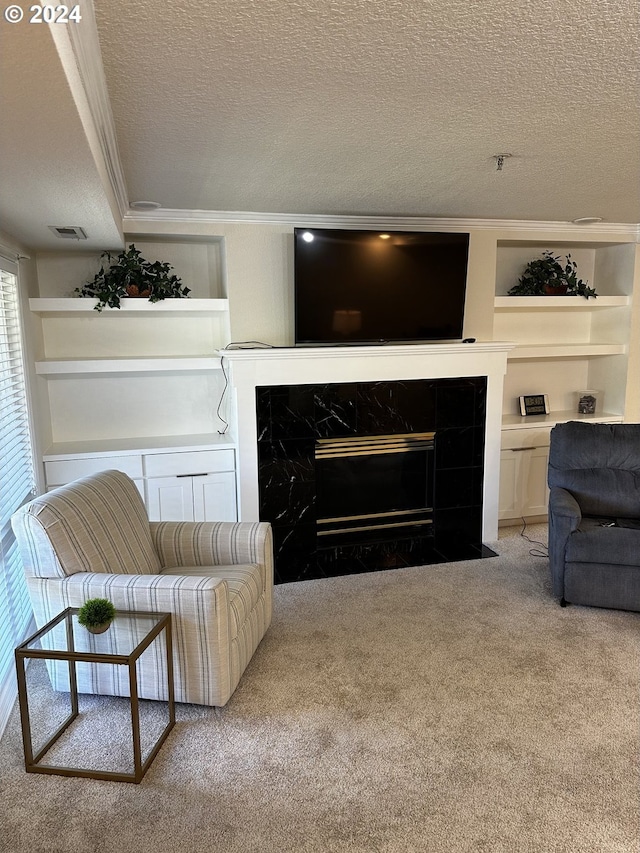 carpeted living room featuring crown molding, built in shelves, a textured ceiling, and a high end fireplace