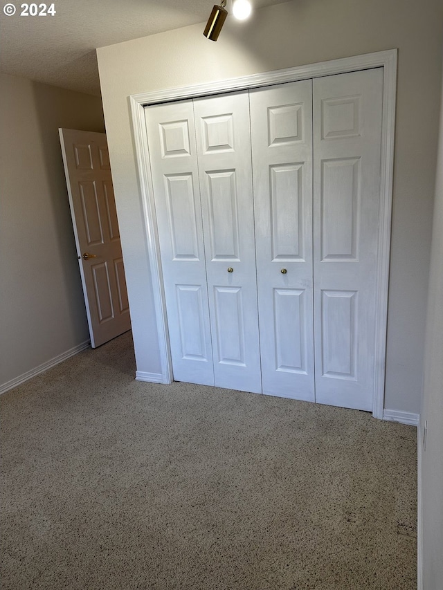 unfurnished bedroom featuring ceiling fan, a closet, and carpet