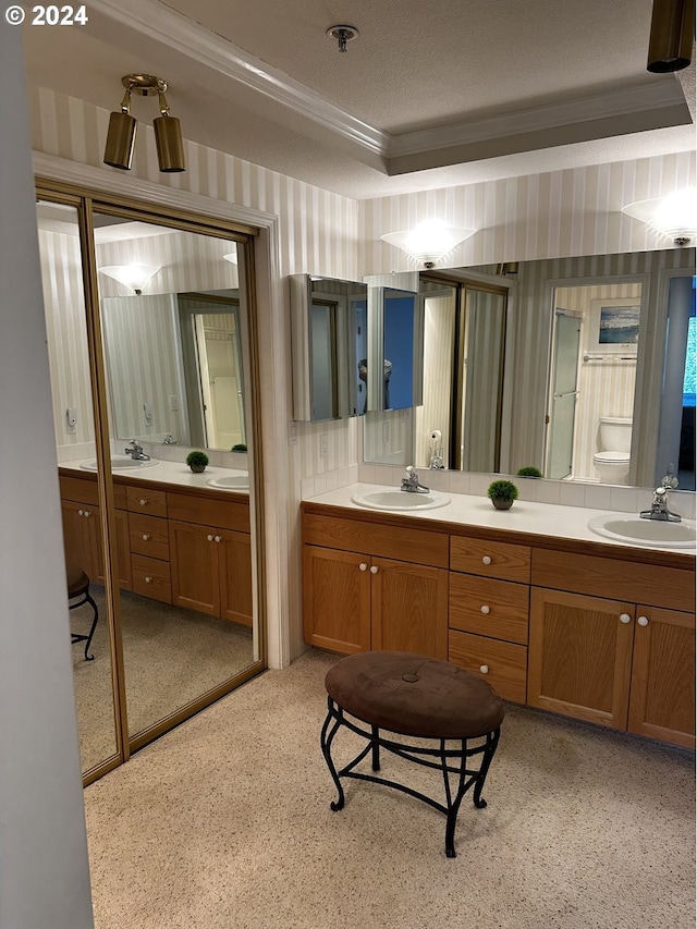 bathroom with dual bowl vanity and ornamental molding