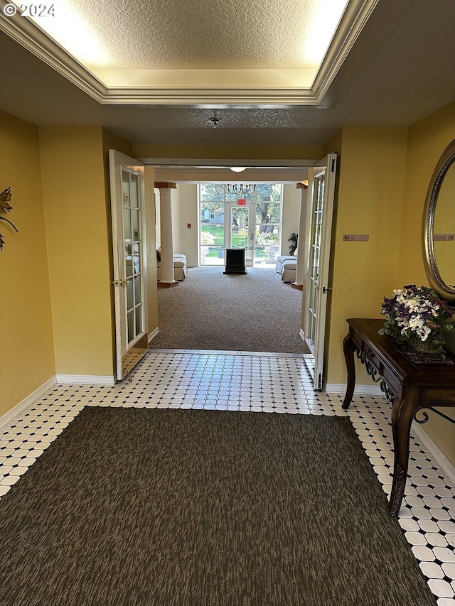 corridor with light tile patterned floors, french doors, and a raised ceiling