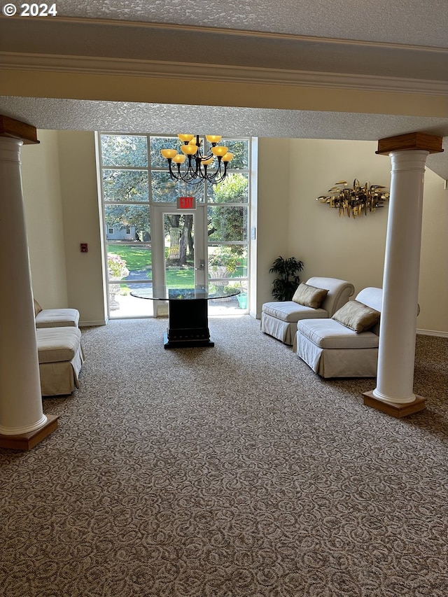 unfurnished living room with ornate columns, a textured ceiling, carpet, and an inviting chandelier