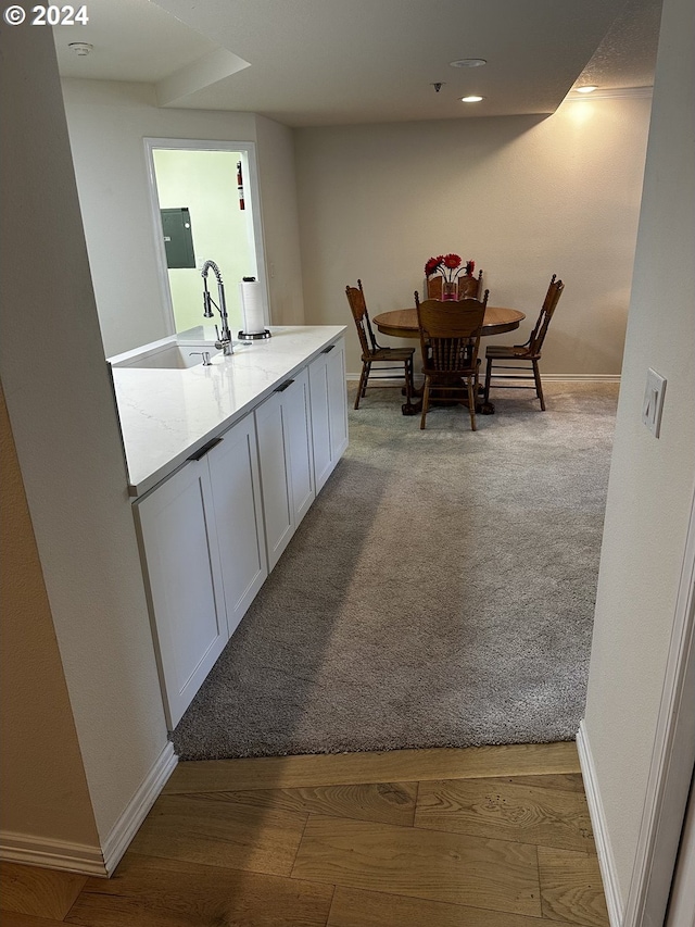 carpeted dining space featuring sink and electric panel