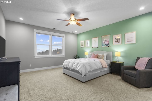 carpeted bedroom with ceiling fan and a textured ceiling