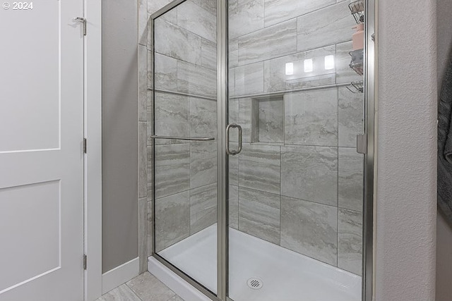 bathroom with a shower with door