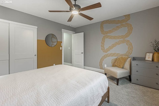 bedroom with ceiling fan, light carpet, and a closet