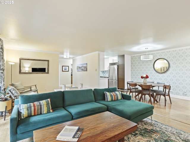 living room featuring ornamental molding, light wood-style floors, baseboards, and wallpapered walls