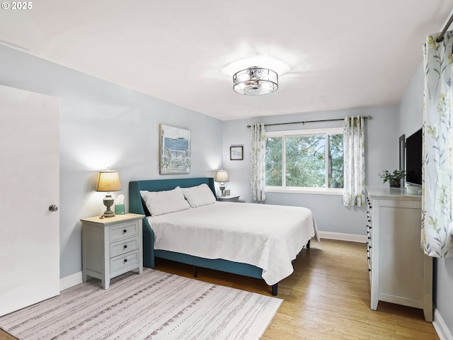 bedroom with light wood-type flooring and baseboards