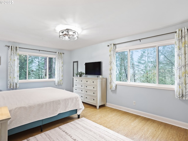 bedroom featuring light wood-type flooring and baseboards