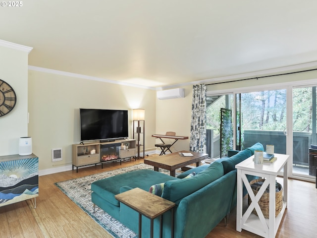 living room with a wall unit AC, visible vents, wood finished floors, and ornamental molding