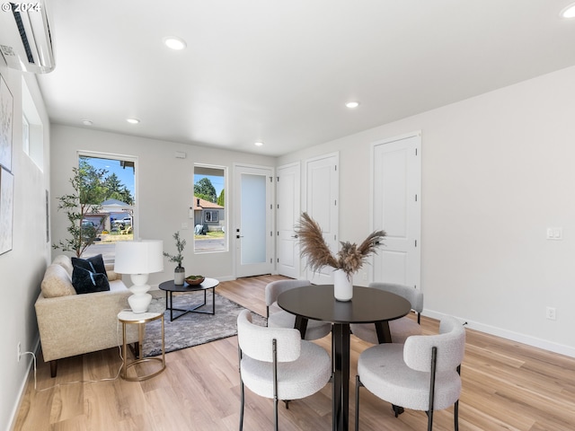 dining room featuring light wood-type flooring and a wall mounted air conditioner