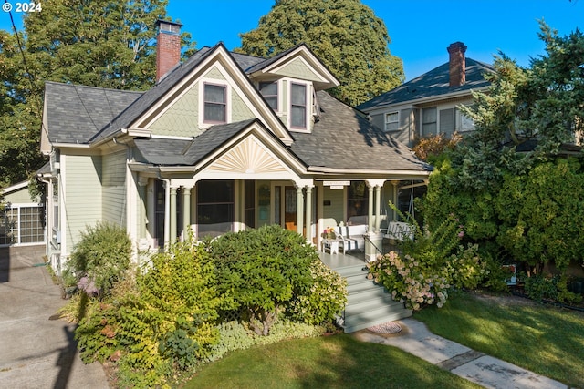 view of front of house with covered porch and a front yard