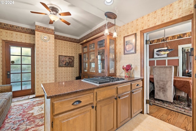 kitchen with ceiling fan, light hardwood / wood-style flooring, decorative light fixtures, and stainless steel gas stovetop