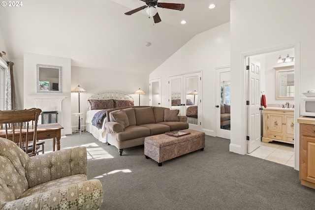 bedroom featuring ceiling fan, light colored carpet, high vaulted ceiling, and connected bathroom