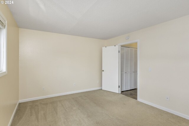 carpeted spare room with a textured ceiling