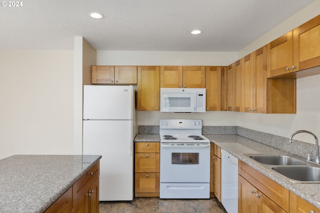 kitchen with a textured ceiling, sink, and white appliances