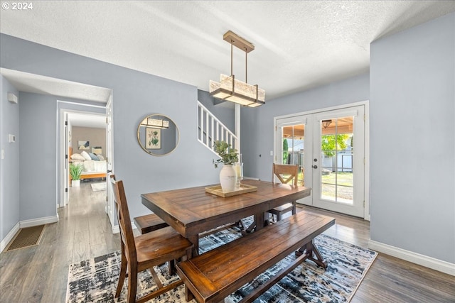 dining area featuring french doors, a textured ceiling, and wood-type flooring