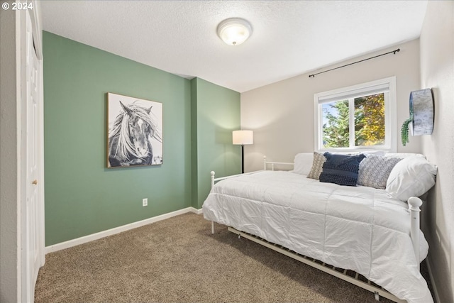 carpeted bedroom featuring a textured ceiling