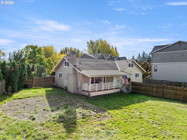 rear view of house featuring a deck and a lawn