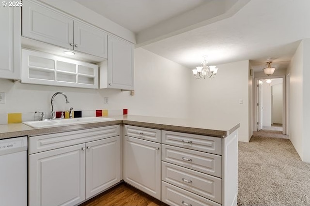 kitchen featuring sink, white cabinetry, light carpet, dishwasher, and beamed ceiling