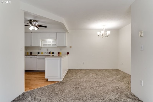 kitchen featuring pendant lighting, white cabinetry, dishwasher, sink, and light colored carpet