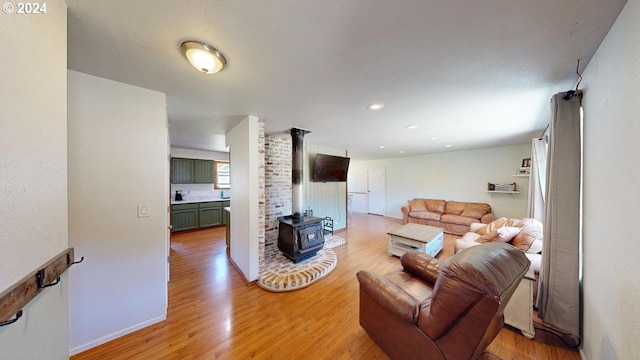 living room featuring wood-type flooring and a wood stove