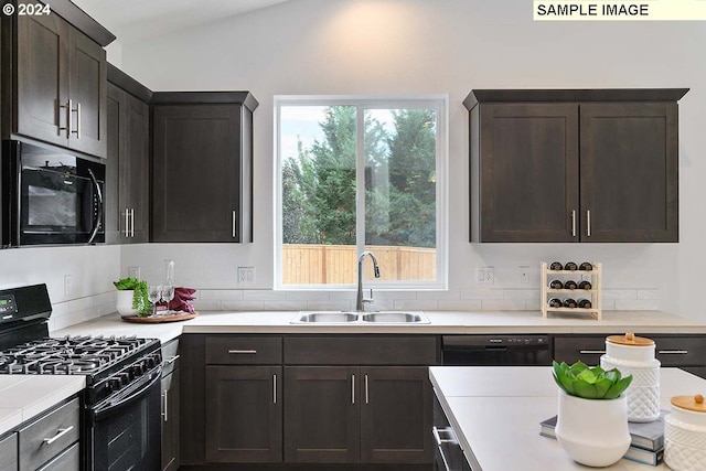 kitchen featuring decorative backsplash, dark brown cabinetry, sink, black appliances, and lofted ceiling