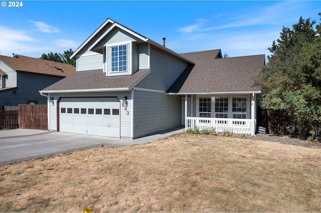 view of front of property with a front lawn, covered porch, and a garage