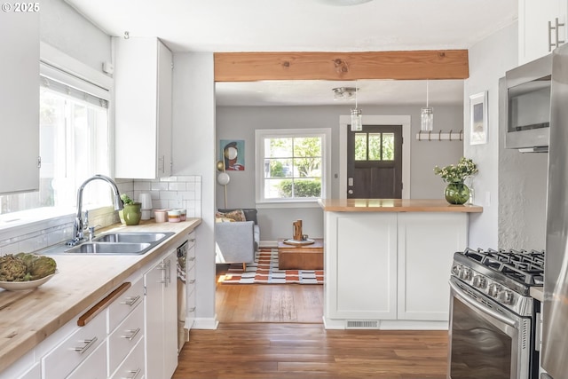 4524 NE 41st Ave, Portland, OR 97211 - kitchen with appliances with stainless steel finishes, white cabinets, wood finished floors, and decorative backsplash