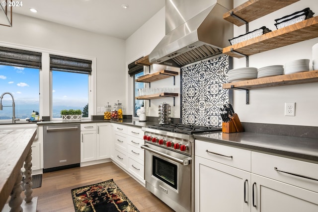 kitchen featuring white cabinetry, appliances with stainless steel finishes, hardwood / wood-style flooring, and island exhaust hood