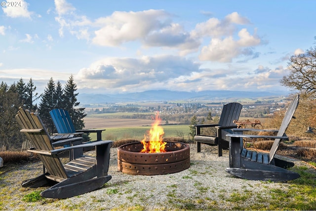 view of yard featuring a mountain view and an outdoor fire pit