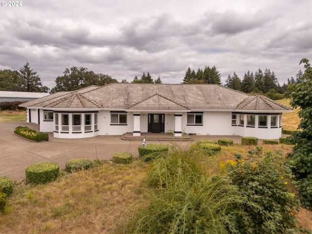 view of front of house with stucco siding and a tiled roof