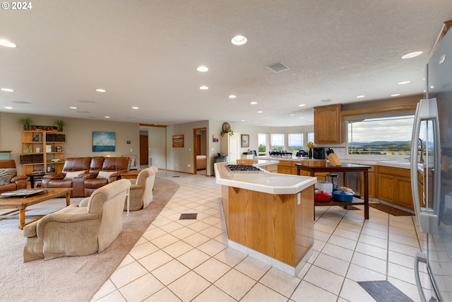 kitchen with a breakfast bar, tile counters, a textured ceiling, and light tile patterned flooring