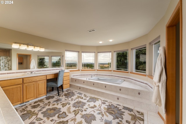 bathroom with tiled tub, vanity, and tile patterned floors