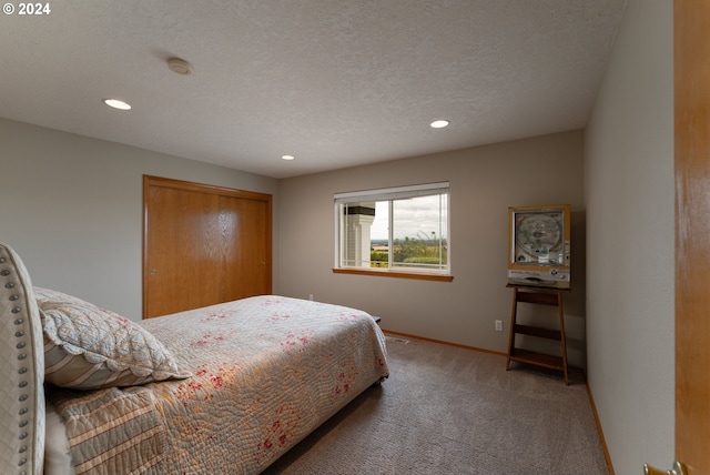 bedroom featuring a textured ceiling, carpet flooring, and a closet