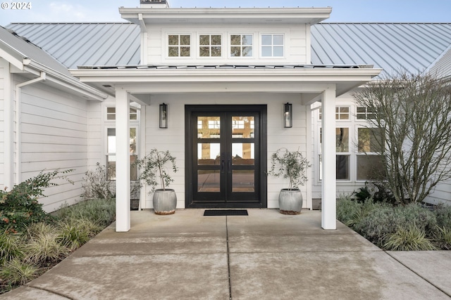 doorway to property with french doors, metal roof, and a standing seam roof