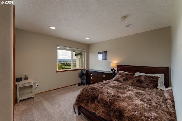 bedroom with light carpet and a textured ceiling