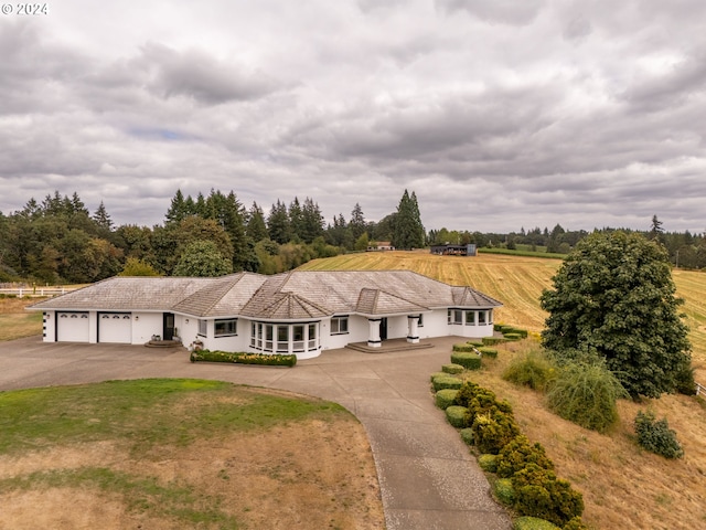 single story home featuring a garage and a rural view