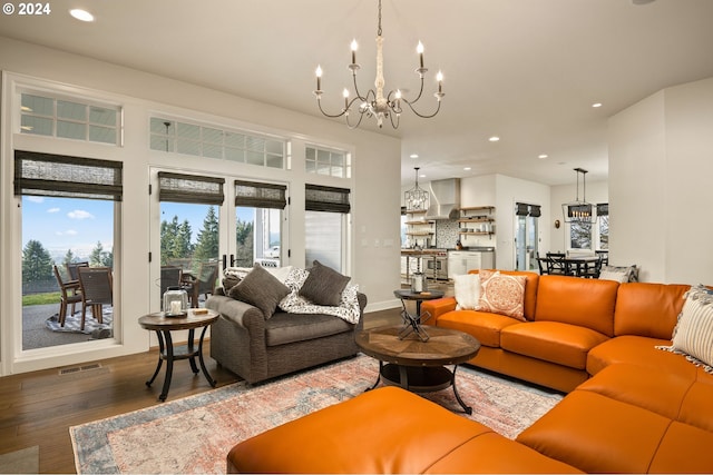 living room with dark wood-type flooring and an inviting chandelier