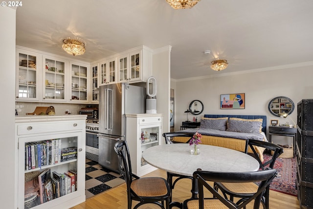 dining area featuring light hardwood / wood-style floors and crown molding