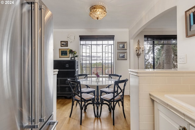 dining area with light hardwood / wood-style flooring and crown molding