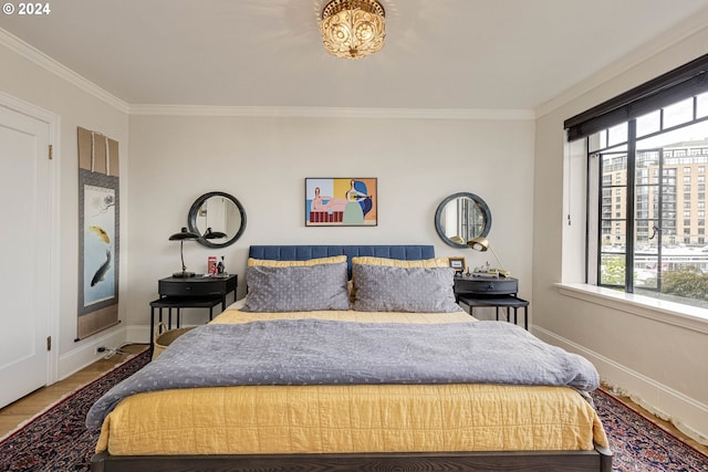 bedroom featuring hardwood / wood-style flooring, ornamental molding, and multiple windows