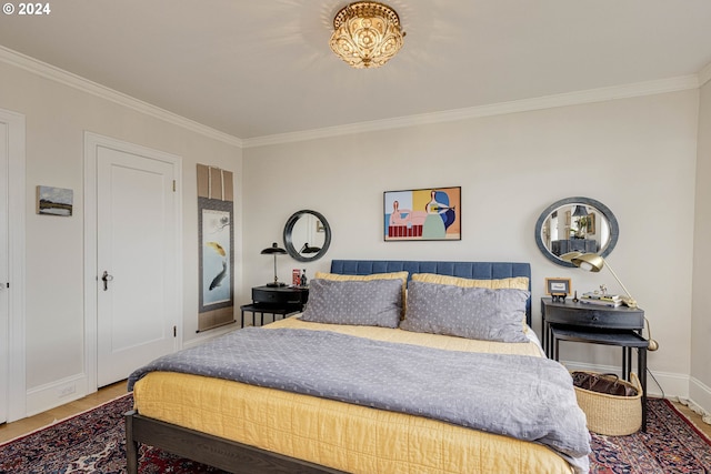 bedroom with baseboards, crown molding, and wood finished floors