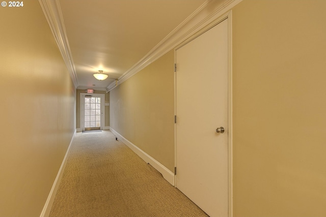 hallway with baseboards, ornamental molding, and light colored carpet