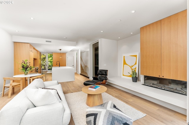 living room with light wood-type flooring and sink