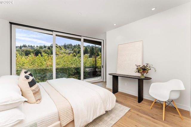 bedroom with light wood-style floors, access to outside, a wall of windows, and recessed lighting