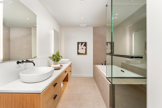 bathroom featuring tiled tub, vanity, and tile patterned floors