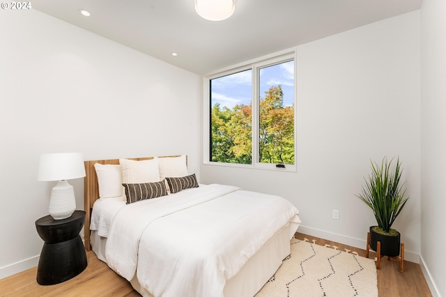 bedroom with light wood-type flooring, baseboards, and recessed lighting