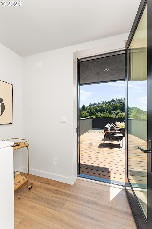 doorway featuring light wood-style flooring and baseboards