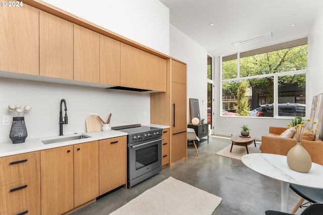 kitchen with electric stove, light brown cabinetry, and sink